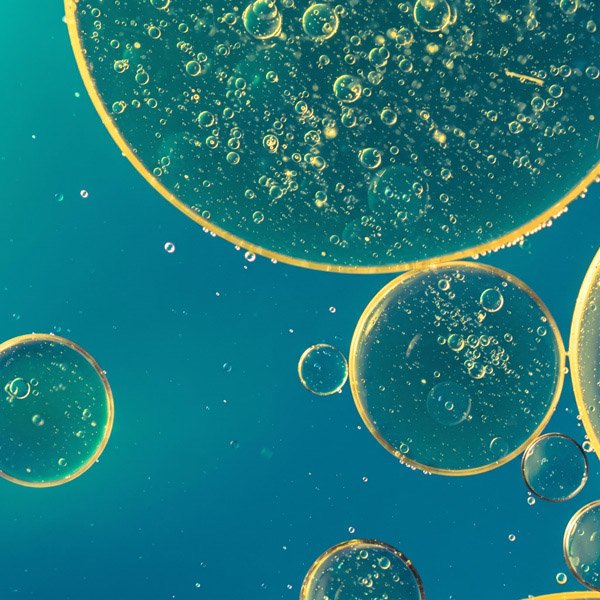 Ilustração abstrata de bolhas douradas e azuis representando a tecnologia de exossomos do CICA EXOSOME